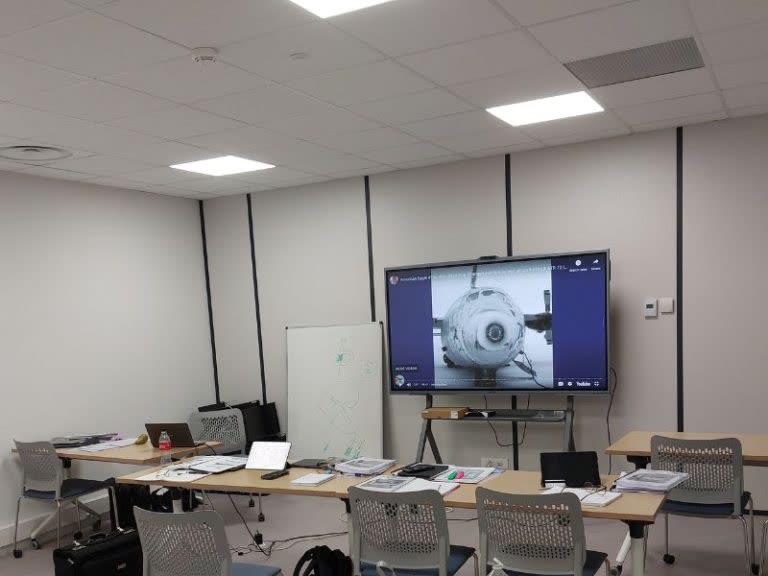 Aviation training classroom with instructor and trainees at modern workstations