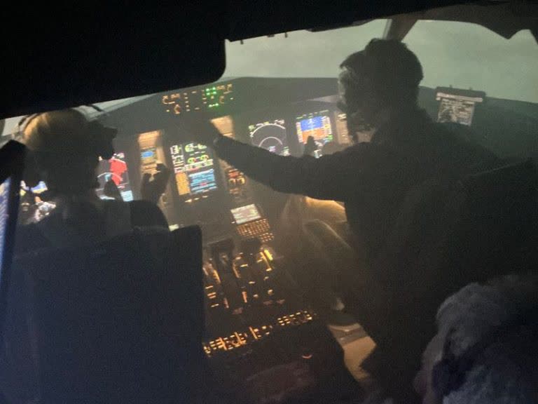 Flight simulator cockpit at night showing pilot in low-light training conditions