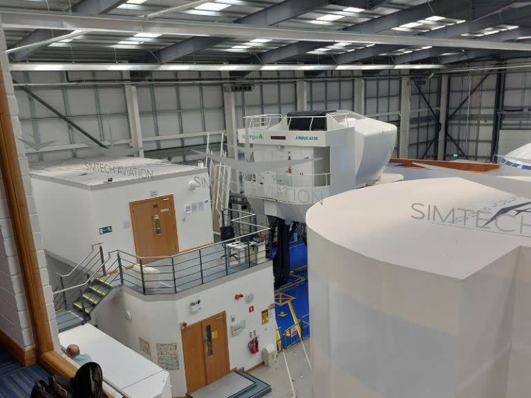 Simtech Aviation facility overview showing multiple full flight simulators in a large training hangar