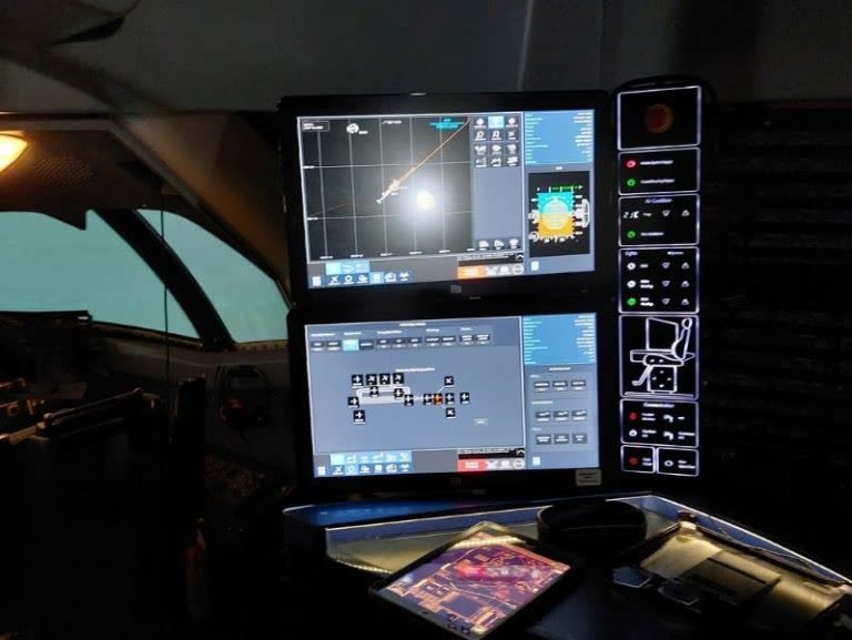 Simulator instructor operating station with multiple screens showing flight data and aircraft systems